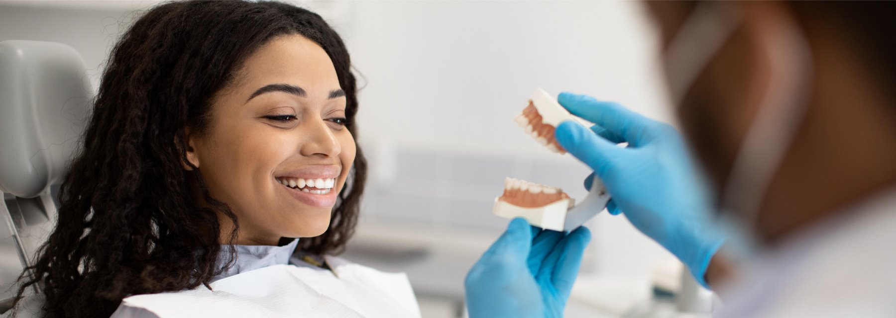 A Dentist Holding A Model Of Teeth In Front Of A Patient In A Dental Clinic at Charleston West Virginia