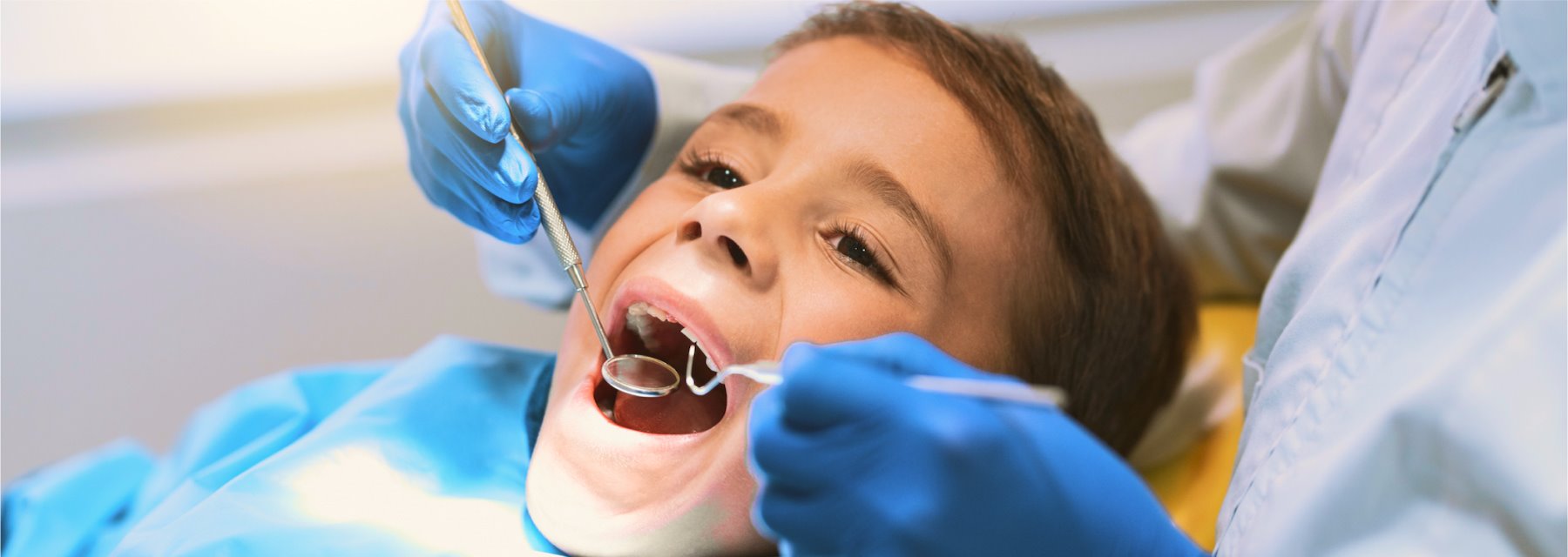 Child Sits In A Dental Chair While A Dentist Examines at Charleston West Virginia