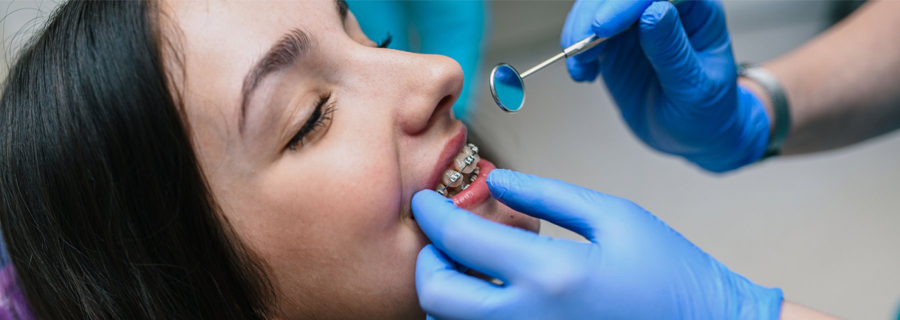 Woman Sits In A Dental Chair While A Dentist Cleans Her Teeth at Charleston West Virginia