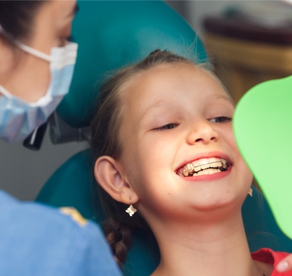 Young Girl Smiles Brightly While Seated In A Dentist Chair at Charleston West Virginia